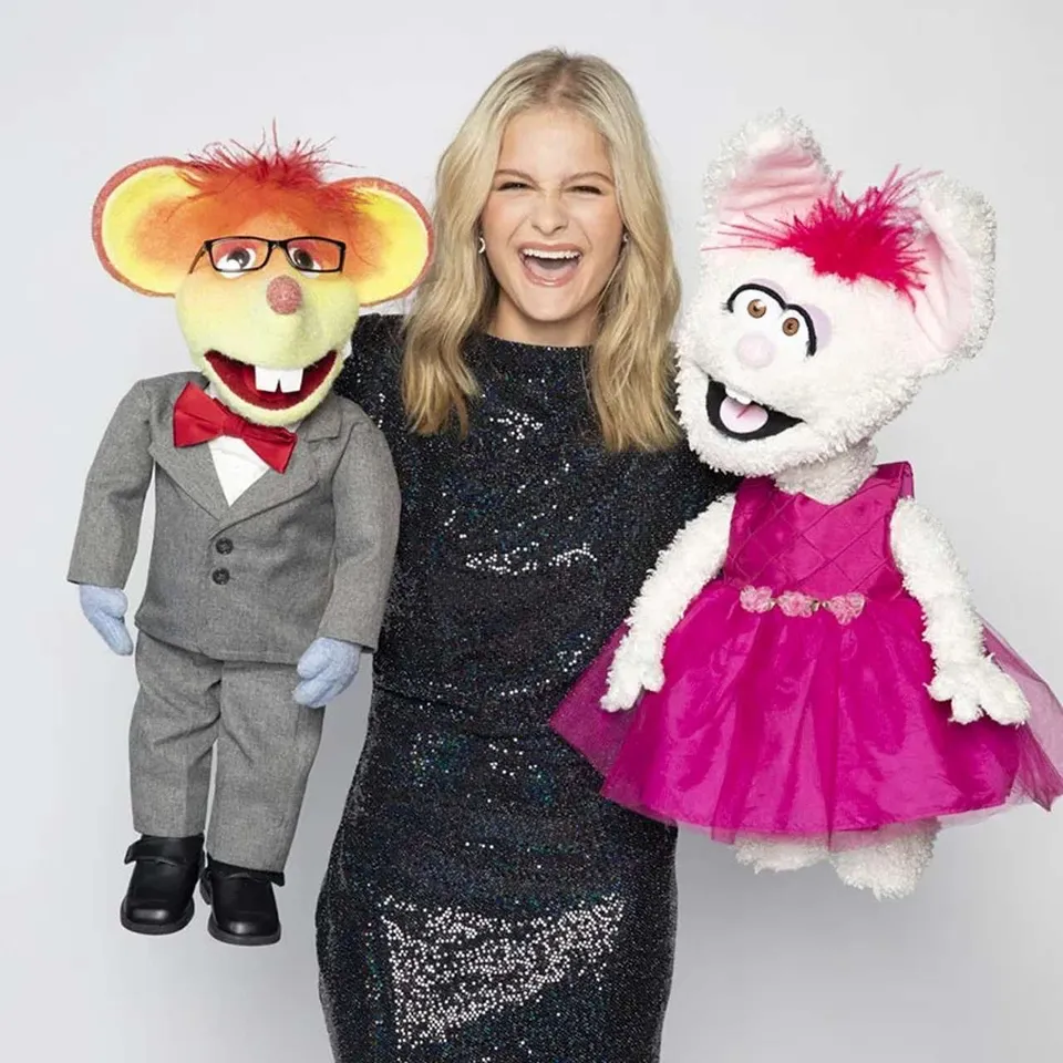 Darci Lynne laughing in a black sequined dress, holding Oscar the mouse and Petunia the rabbit
